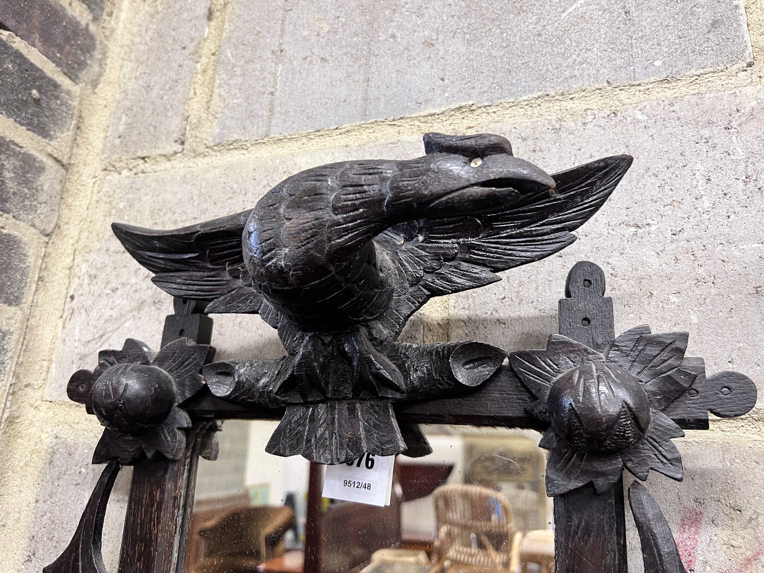 A late 19th century Black Forest ebonised oak wall mirror with eagle surmount, width 46cm, height 65cm